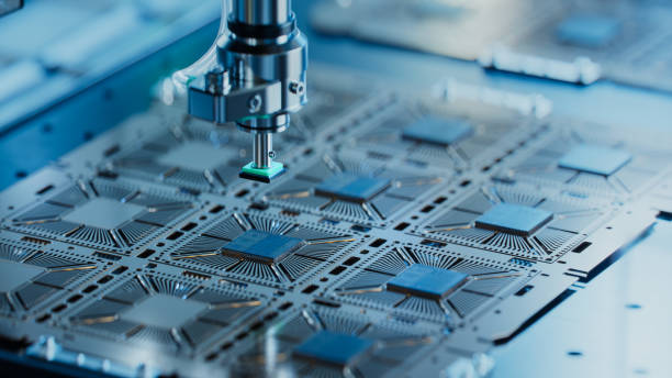 Close-up of a precision instrument assembling nanotechnology components on electronic circuit boards.